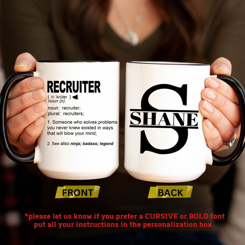 May include: White ceramic coffee mug with a black handle. The front of the mug has the word "RECRUITER" defined as "Someone who solves problems you never knew existed in ways that will blow your mind". The back of the mug has the name "SHANE" written in black letters across a large black letter "S".