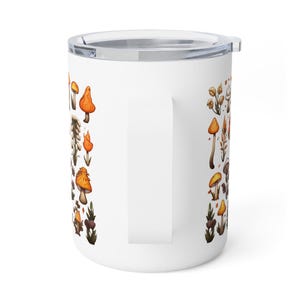 May include: White ceramic travel mug with a stainless steel lid and handle. The mug features a pattern of orange and yellow mushrooms with brown stems and leaves.