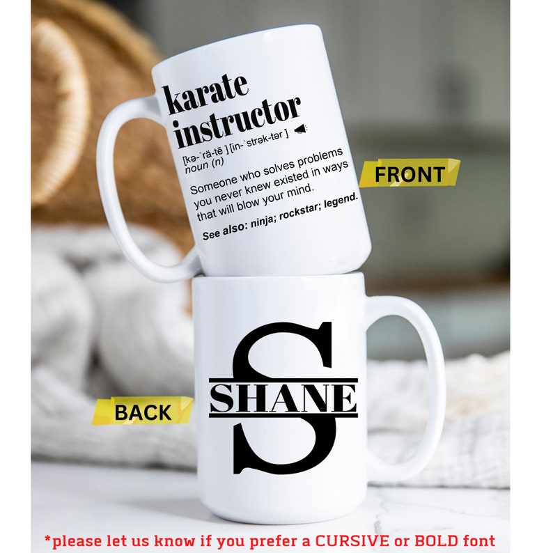May include: White ceramic mug with a black handle. The front of the mug has the text "karate instructor" with a definition. The back of the mug has a black letter "S" with the name "SHANE" written across the middle of the letter.