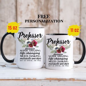Op de afbeelding: Twee witte keramische mokken met zwarte randen en handvatten. De mokken hebben een bloemenmotief en de tekst "Professor because super amazing life changing multi-tasking miracle worker isn't an official job title". De mokken zijn verkrijgbaar in de maten 11 oz en 15 oz.