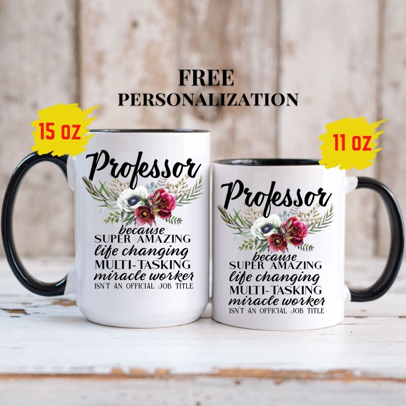 Op de afbeelding: Twee witte keramische mokken met zwarte randen en handvatten. De mokken hebben een bloemenmotief en de tekst "Professor because super amazing life changing multi-tasking miracle worker isn't an official job title". De mokken zijn verkrijgbaar in de maten 11 oz en 15 oz.