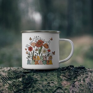 May include: White enamel camping mug with a floral design and the text "Ninja Rockstar Legend Case Manager".