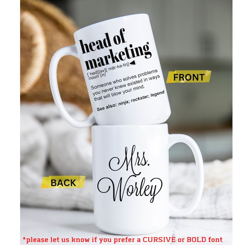 May include: Two white ceramic mugs stacked on top of each other. The top mug reads "head of marketing" with a definition. The bottom mug says "Mrs. Worley" in cursive. The front and back of the mugs are labeled.