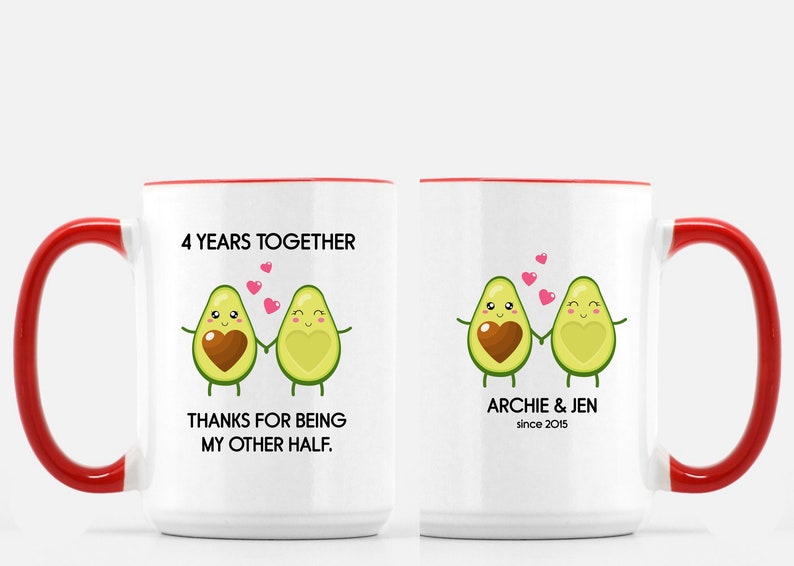 Puede incluir: Dos tazas de cer&aacute;mica blanca con asas rojas. Una taza tiene el texto "4 Years Together" y "Thanks for being my other half." con una imagen de dibujos animados de dos aguacates tom&aacute;ndose de la mano. La otra taza tiene el texto "Archie & Jen since 2015" con una imagen de dibujos animados de dos aguacates tom&aacute;ndose de la mano.