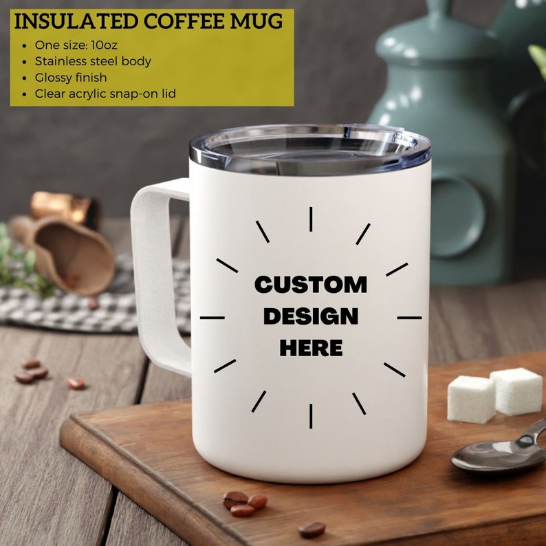 May include: White insulated coffee mug with a clear acrylic snap-on lid. The mug has a stainless steel body and a glossy finish. The text "CUSTOM DESIGN HERE" is printed on the front. The mug is approximately 10oz.
