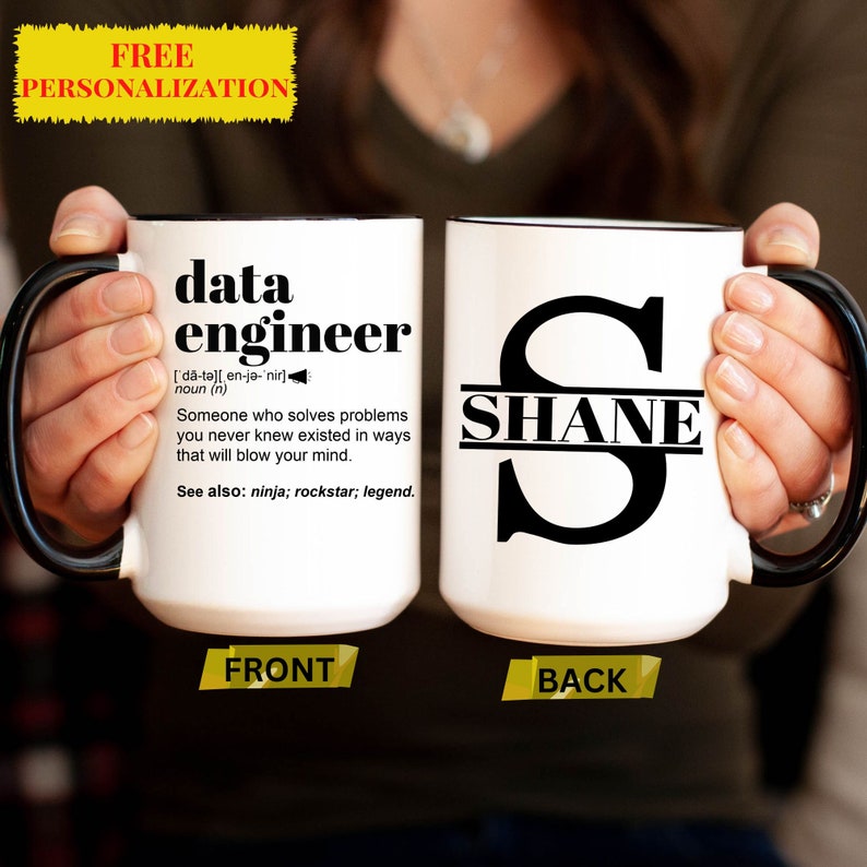 May include: White ceramic mug with black handle and rim. The front of the mug has the definition of "data engineer". The back of the mug has the name "SHANE" under a large letter "S". The mug is personalized.