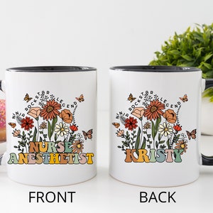 Puede incluir: Taza de caf&eacute; de cer&aacute;mica blanca con borde y asa negros. La parte delantera de la taza presenta un dise&ntilde;o floral con el texto "Nurse Anesthetist" en letras de colores. La parte trasera de la taza presenta el mismo dise&ntilde;o floral con el nombre "Kristy" en letras de colores.