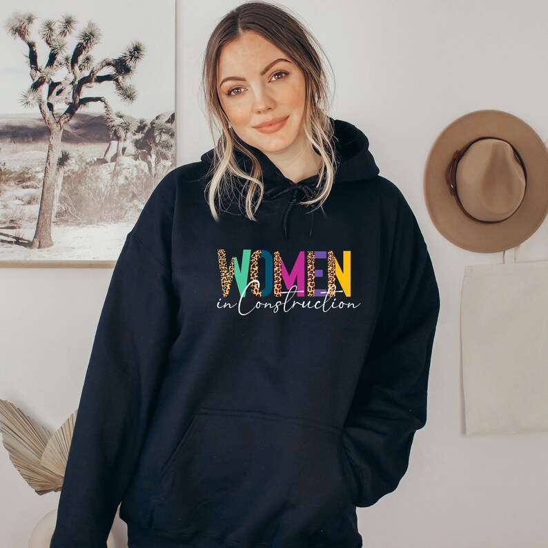 May include: Black hooded sweatshirt with the text "WOMEN in Construction" in colorful letters with a leopard print pattern.