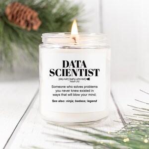 May include: A white candle in a clear glass jar with a black label that reads "DATA SCIENTIST [dey-tuh] [sahy-uhn-tist] noun (n) Someone who solves problems you never knew existed in ways that will blow your mind; See also: ninja; badass; legend"