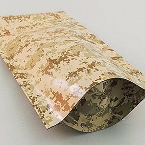 Puede incluir: Una bolsa de color camuflaje marr&oacute;n y beige con una solapa superior y una costura termosellada. La bolsa est&aacute; hecha de un material flexible y es ideal para empaquetar y guardar objetos peque&ntilde;os.
