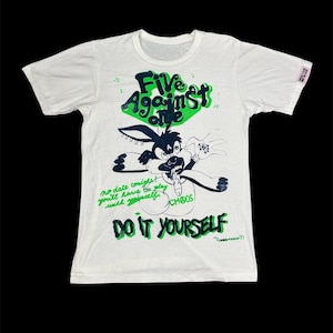 May include: White t-shirt with a cartoon graphic of a rabbit and text in green and black. The text includes "Five Against Life", "Do It Yourself", and other phrases.
