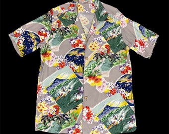 May include: A gray short-sleeved shirt with a colorful floral print featuring palm trees, mountains, and surfers. The shirt has a button-up collar and a button-down front.