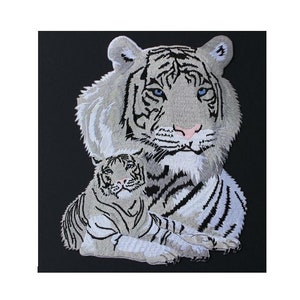 May include: Embroidered patch featuring a white tiger with blue eyes and a smaller white tiger cub. The tigers are sitting on a black background.