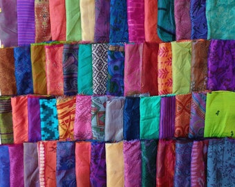 May include: A collection of colorful fabric scraps in various patterns and textures. The scraps are arranged in rows and are mostly made of silk.