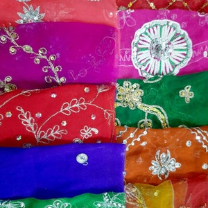 May include: A stack of colorful sheer fabric scarves with silver embroidery and sequins. The scarves are in shades of red, pink, green, blue, and orange.