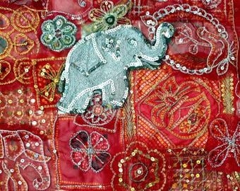 May include: A red fabric with silver sequins and embroidery. The fabric features a silver embroidered elephant with a raised trunk.