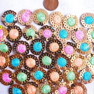 以下が含まれることがあります： 金色のスパンコールが付いたカラフルな刺繍の花の装飾品のアソートメント。装飾品の直径は約2.5cmです。