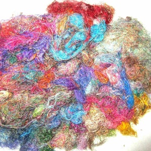 May include: A pile of colourful, iridescent, and textured fibres. The fibres are a mix of blues, greens, reds, pinks, and golds. The fibres are tangled and overlapping, creating a chaotic and abstract pattern.