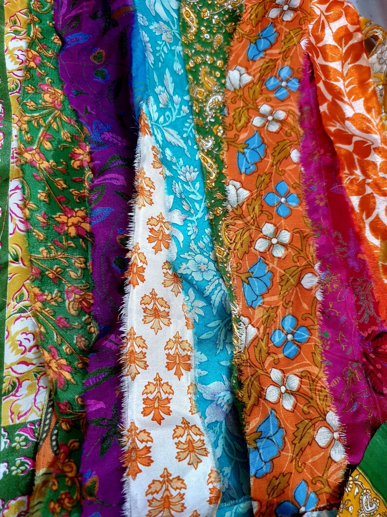 May include: A close-up of a colorful fabric scrap with various floral patterns in shades of green, blue, orange, purple, and white.