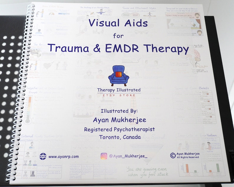 May include: A white spiral bound book with the title "Visual Aids for Trauma & EMDR Therapy" and the text "Therapy Illustrated Etsy Store" and "Illustrated By: Ayan Mukherjee Registered Psychotherapist Toronto, Canada" on the cover. The book has a blue armchair with a red pillow on the cover.