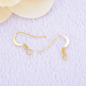 May include: Two gold-colored earring hooks. Each hook features a curved design with a coiled spring and a small loop at the bottom. The hooks are designed for jewelry making and crafting.