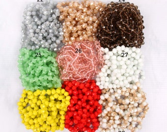 May include: Assortment of 10 strands of faceted glass beads in various colors, including silver, beige, brown, green, pink, white, yellow, red, and cream.