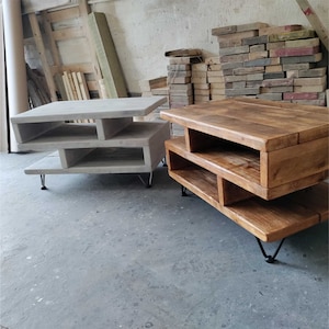 Showing the Greek Meander shape side profile of the rustic coffee table with the optional raw steel 10cm hairpin legs on the medium size white smoke stained table on the left and medium size natural oak stained table on the right.