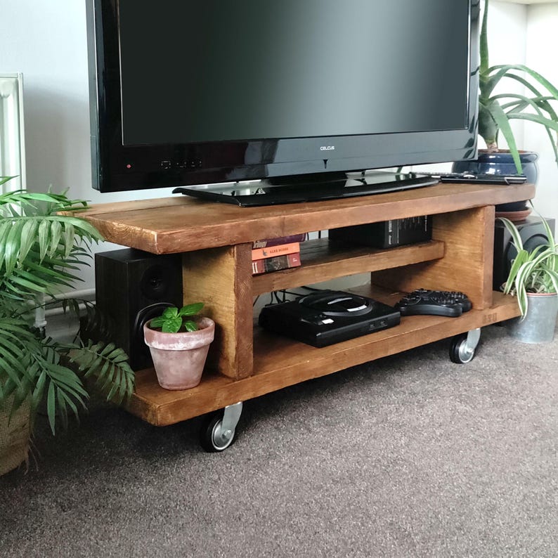 Rustic TV Stand with Wheels shown with its multiple storage compartments in use.