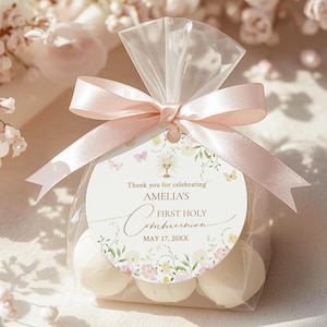 Może przedstawiać: Biały ceramiczny kubek z czarnym uchwytem i napisem "But First, Coffee" w stylu odręcznym. Kubek stoi na białej powierzchni. Kubek ma około 10 cm wysokości.