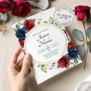 May include: A rectangular wedding invitation card featuring a floral border of deep red and navy blue roses with green eucalyptus leaves and gold speckles. The centre has a gold circular frame with text: Welcome to the wedding of Jessica & Nicolas.