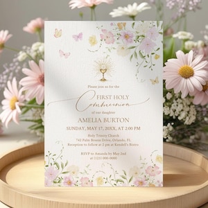 May include: A First Holy Communion invitation with floral and butterfly designs. The invitation includes the text "First Holy Communion" and details for Amelia Burton's ceremony, including the date, time, and location. The invitation is on a wooden tray with flowers.
