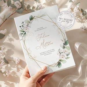 May include: A rectangular wedding invitation card featuring a gold geometric frame, white floral illustrations, and green eucalyptus leaves. The text reads: Welcome to the wedding of Felicia & Matthew, Saturday, June 27, 20XX, Woodland Grand Mansion, Pensacola, FL.