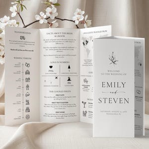 May include: A white wedding program, folded into thirds, with black text and illustrations. The program includes details about the wedding timeline, facts about the bride and groom, and a map showing where guests traveled from. The front cover reads "Welcome to the Wedding of Emily and Steven."