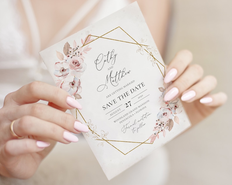 May include: A floral wedding invitation with the names "Cathy" and "Matthew" in elegant script. The invitation features a gold geometric frame and delicate watercolor flowers in shades of pink and beige. The text "Save the Date" is prominently displayed.