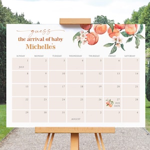 May include: A light peach-colored baby shower calendar with the text "Guess the arrival of baby Michelle's." The calendar features a peach and floral design, with the due date marked on July 27th.