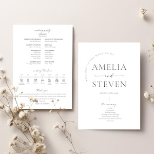 May include: Two white wedding stationery cards with black text. One card lists the wedding party, including the officiant, parents, and wedding party members. The other card says "Welcome to the Wedding of Amelia and Steven" and the date.