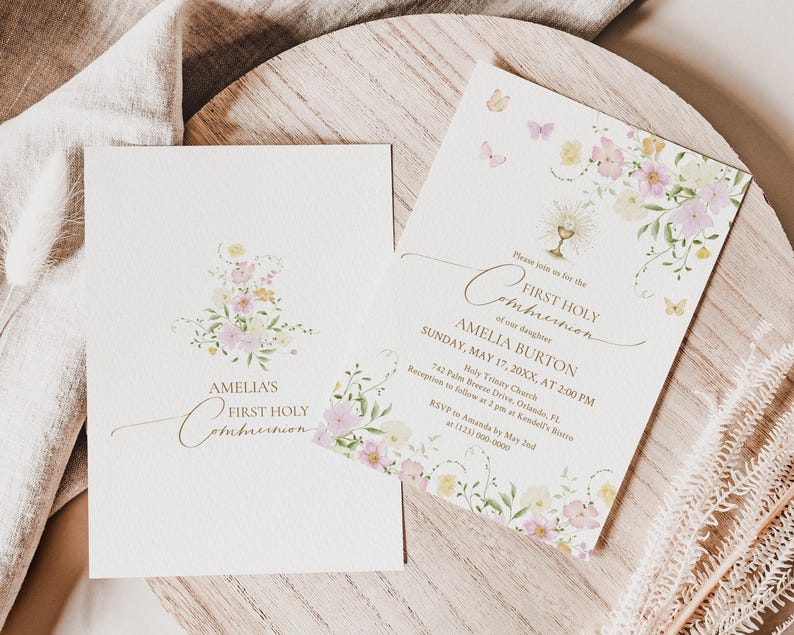 May include: Two First Holy Communion invitations. The invitations are cream-colored with floral and butterfly accents in pastel colors. The text reads "Amelia's First Holy Communion" and includes event details.