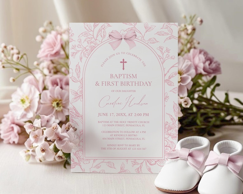May include: A pink floral baptism and first birthday invitation card with text. The card features the name "Caroline Hudson" and event details. Two white baby shoes with pink bows are in the foreground. The card is surrounded by pink flowers.