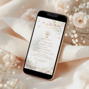 May include: A smartphone displays a First Holy Communion invitation. The invitation features floral and butterfly illustrations in soft pastel colors. The text includes the name Amelia Burton, the date, time, and location of the event.