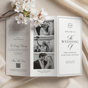 May include: A tri-fold wedding program featuring black and white photos of the couple. The program includes the text "Welcome to The Wedding Of Emily Burton & Michael Hudson" and "In Loving Memory". White flowers are in the upper left corner.