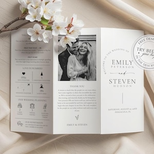 Może przedstawiać: Trójstronna zaproszenie ślubne ze zdjęciem pary w czerni i bieli. Zaproszenie zawiera tekst, taki jak "Witamy na ślubie Emily Peterson i Stevena Hudsona" i "Dziękuję". Gałązka białych kwiatów spoczywa po lewej stronie.
