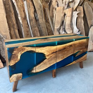 May include: A wooden cabinet with three doors and a blue resin inlay. The cabinet has a modern design and is made of natural wood.