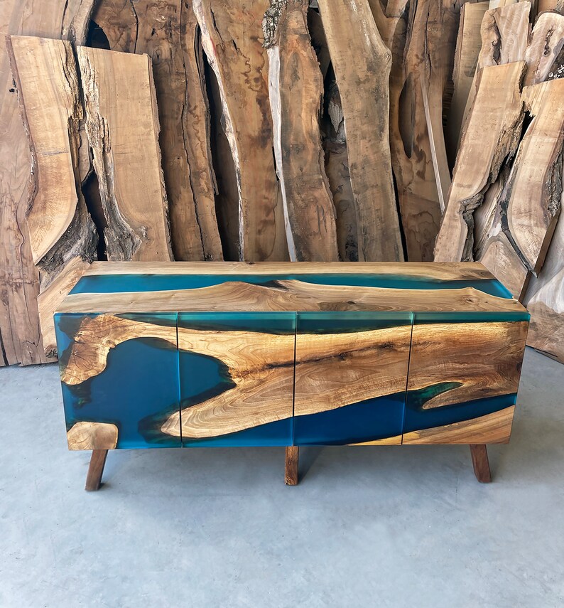 May include: A wooden cabinet with three drawers and a blue resin inlay. The cabinet has a modern design and is made of natural wood.