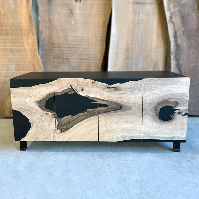 May include: A black cabinet with three doors made of wood with black epoxy resin filling in the natural knots. The cabinet has a modern design and is perfect for a living room or dining room.