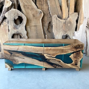 Könnte beinhalten: Ein Holzschränkchen mit drei Türen zeigt ein einzigartiges Design mit türkisfarbenem Harz, das durch die Holzmaserung fließt. Der Schrank hat einen modernen, zeitgenössischen Stil.