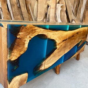 May include: A wooden cabinet with three doors and a blue resin inlay. The cabinet has a modern design and is made of natural wood.