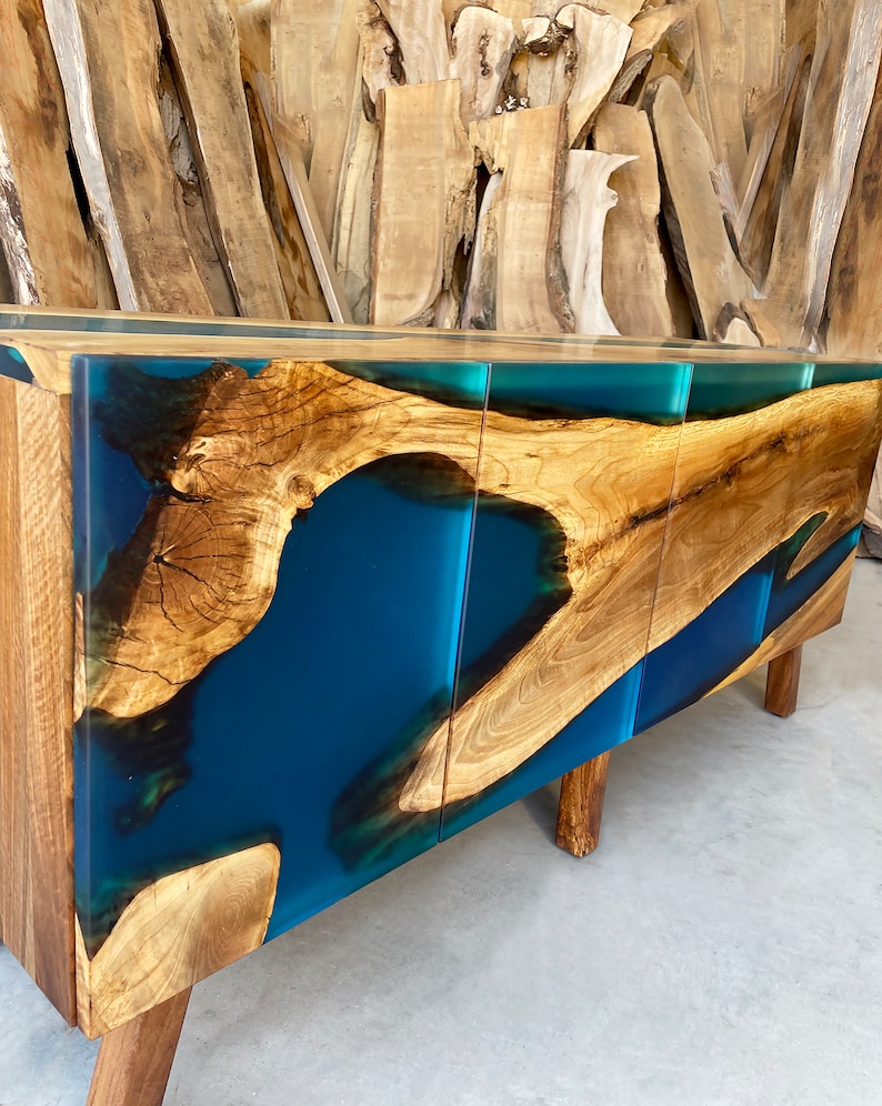 May include: A wooden cabinet with three doors and a blue resin inlay. The cabinet has a modern design and is made of natural wood.