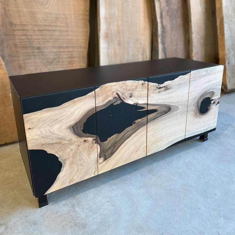 May include: A black cabinet with three doors made of wood with black epoxy resin filling the natural wood grain. The cabinet has a modern design and is perfect for a living room or dining room.