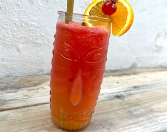 May include: A red and orange tiki-style cocktail in a glass with a straw and a slice of orange and a cherry on top.