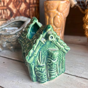 Handmade ceramic Tiki mug shaped like a little grass shack hut with detailed tropical decorations.